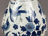 a blue and white vase with birds and flowers on it