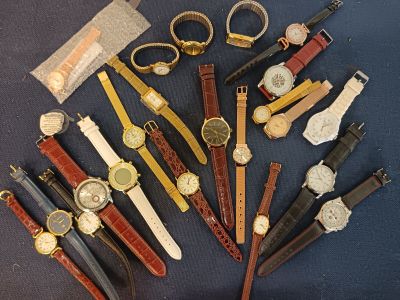 many different types of watches on a blue surface