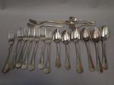 a lot of silver spoons and forks laid out on a table