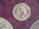 two silver coins sitting on top of a red surface