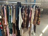 a lot of clothes hanging on a rack in a room
