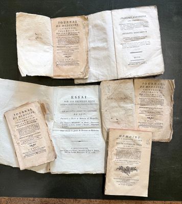 several old books are sitting on a table next to each other