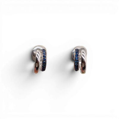 une paire de boucles d'oreilles en argent et saphir bleu sur fond blanc