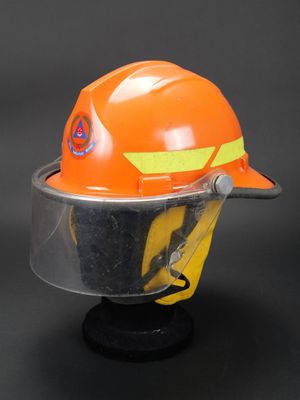 un casque de chantier orange muni d'une visière transparente