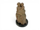 an image of a sculpture of a couple sitting on top of a rock