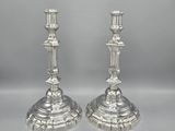 a pair of silver candlesticks on a white background