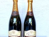 deux bouteilles de champagne posées l'une à côté de l'autre sur une table