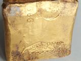 a close up of a piece of gold on a white surface