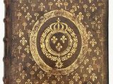 an old book with gold and black designs on it