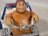 a figurine of a man riding a toy car