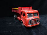 a red toy truck that is sitting on a black surface