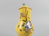 a yellow vase with a floral design on it