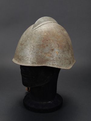 un vieux casque est posé sur un socle noir
