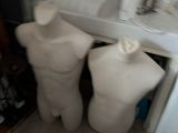two mannequins standing in a bathroom next to a sink