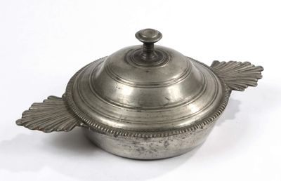 une casserole en argent avec un couvercle, posée sur une surface blanche