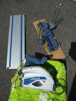 une machine bleue et blanche et un sac vert posé par terre