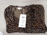 leopard print shirt on a white surface with a price tag on it