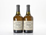 deux bouteilles de vin posées l'une à côté de l'autre sur une surface blanche
