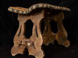 a small wooden stool with a green seat on a black background