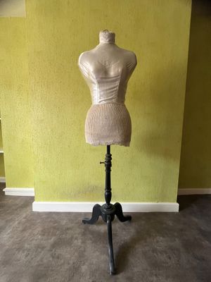 un mannequin assis sur un socle dans une pièce