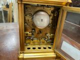 a gold clock sitting on top of a wooden table