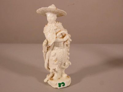 une figurine représentant une femme coiffée d'un chapeau
