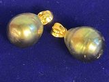 une paire de boucles d'oreilles en forme de perles dorées sur fond bleu
