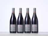 three bottles of red wine sitting on top of a table