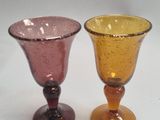 two wine glasses sitting next to each other on a table