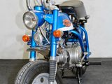 a blue motorcycle parked in a room with a white wall