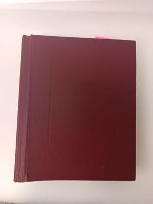 un livre rouge posé sur une table blanche