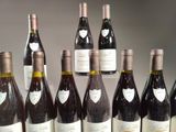 many bottles of wine that are lined up on a table