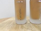 two bottles of liquid sitting on top of a wooden table