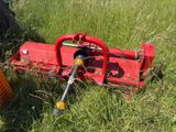 une petite machine rouge qui est posée dans l'herbe