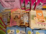 many bags of cat food sitting on a table
