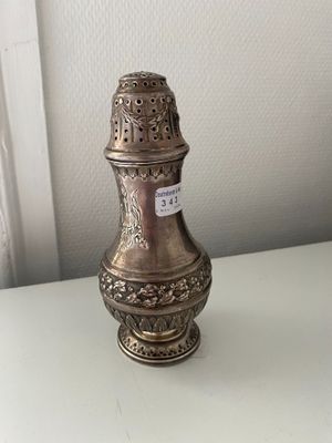 a silver vase sitting on a table with a tag on it