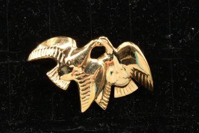 a gold bird that is sitting on top of a black surface