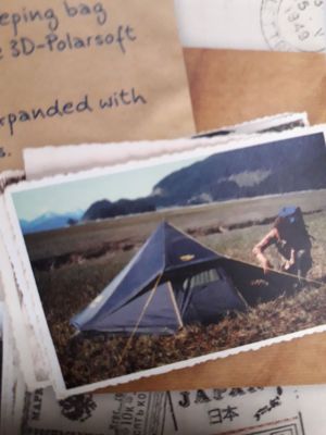 une carte postale sur laquelle figure la photo d'un homme en train de monter une tente
