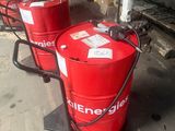 Plusieurs fûts rouges sont alignés les uns à côté des autres dans un garage