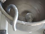 a metal mixing bowl with a handle on a counter