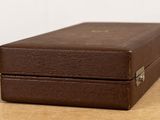 a brown suitcase sitting on a table with a white wall in the background