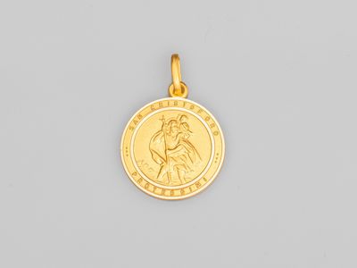 un pendentif en forme de médaille de saint Benoît plaqué or