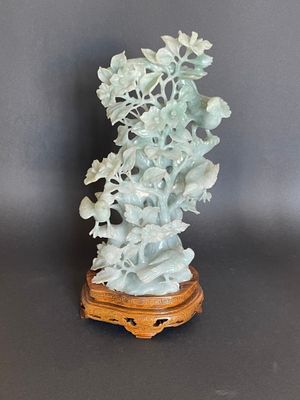 Figurine chinoise en jade sculpté représentant des fleurs et des feuilles, posée sur un socle