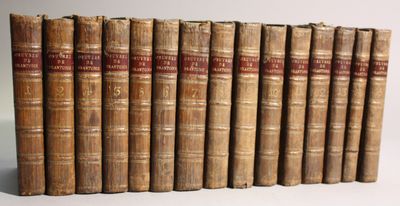 several old books are lined up in a row on a white surface