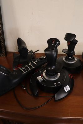 a lot of joysticks sitting on a wooden table