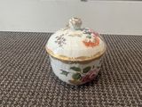 a small bowl with a lid sitting on a carpet