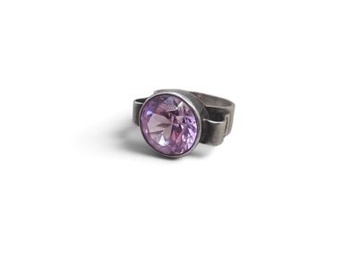 a close up of a ring with a purple stone on it