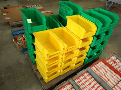 many yellow and green bins stacked on a pallet