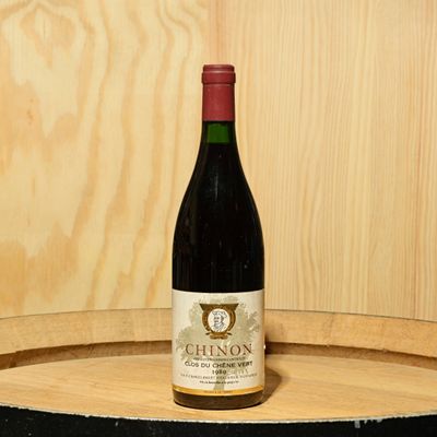 a bottle of wine sitting on top of a barrel