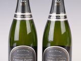 two bottles of champagne sitting next to each other on a table